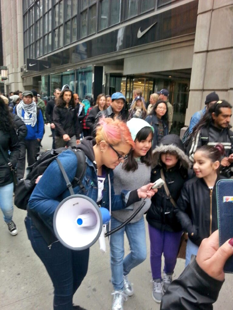 Jamila Hammami protesting with youth protesters. Jamila Hammami chanted the chant into the microphone, and then gave the microphone to Trump 1.0 youth protesters so they could lead chants during with march.