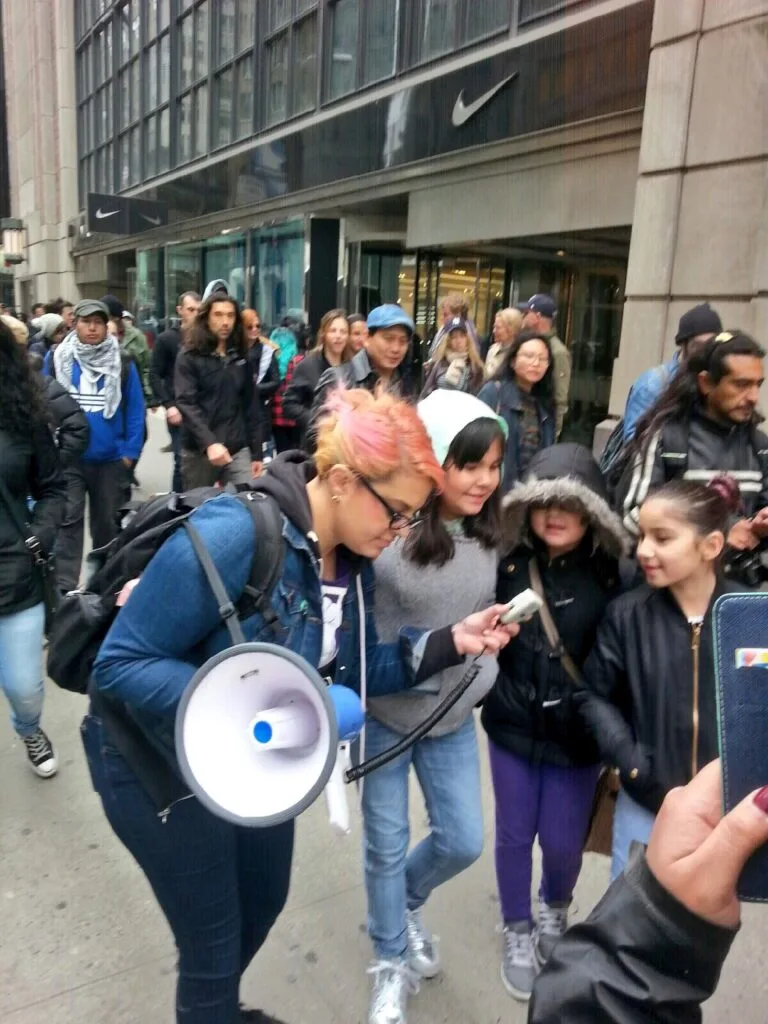 Jamila Hammami protesting with youth protesters. Jamila Hammami chanted the chant into the microphone, and then gave the microphone to Trump 1.0 youth protesters so they could lead chants during with march.